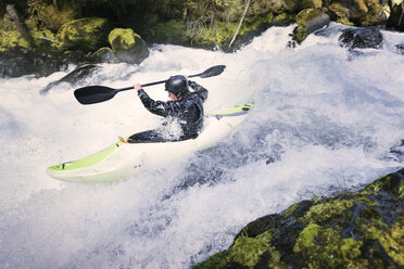 Side view of man kayaking at river - CAVF04350