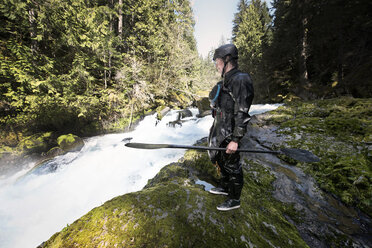 Mann hält Ruder und steht am Fluss - CAVF04352