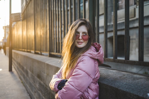 Porträt einer jungen Frau, die auf den Sonnenuntergang wartet, lizenzfreies Stockfoto