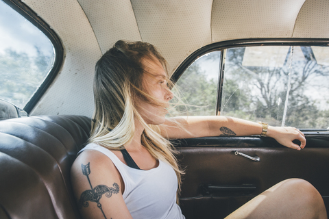 Kuba, Junge Frau sitzt in einem Oldtimer, lizenzfreies Stockfoto