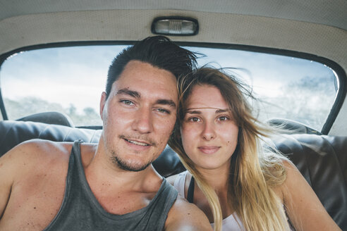 Kuba, ein junges Paar sitzt in einem Oldtimer und macht ein Selfie - GUSF00547