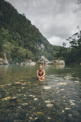 Kuba, Baracoa, Junge Frau sitzt im Yumuri-Fluss - GUSF00559