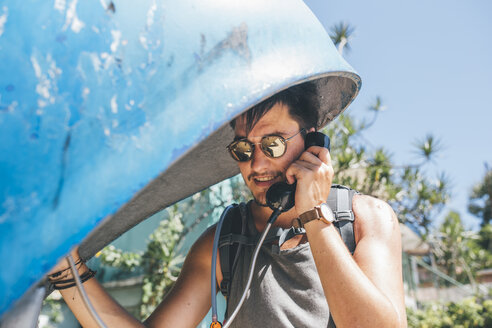 Kuba, Junger Mann, der von einer Telefonzelle aus telefoniert - GUSF00563