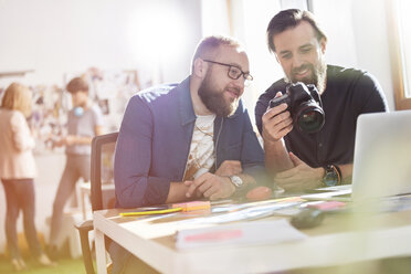 Fotograf Designprofis mit Spiegelreflexkamera im Büro - CAIF09236