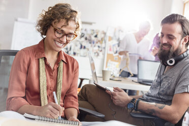 Lächelnde Design-Profis beim Treffen und Skizzieren im Büro - CAIF09239