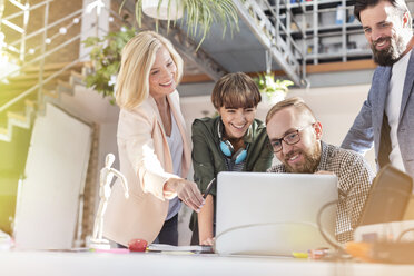 Lächelnde Design-Profis treffen sich im Büro am Laptop - CAIF09254