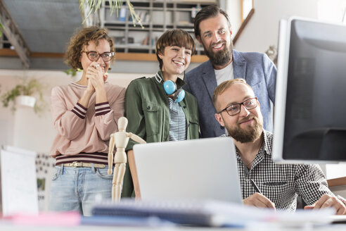 Lächelnde Design-Profis treffen sich am Computer im Büro - CAIF09256