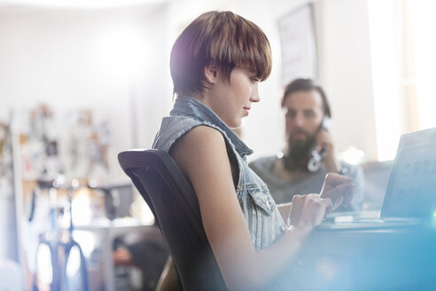 Weibliche Designerin arbeitet am Laptop im Büro - CAIF09264