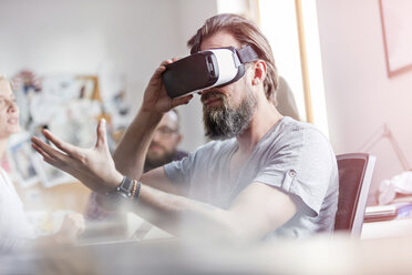 Male design professional using virtual reality simulator glasses in office - CAIF09288
