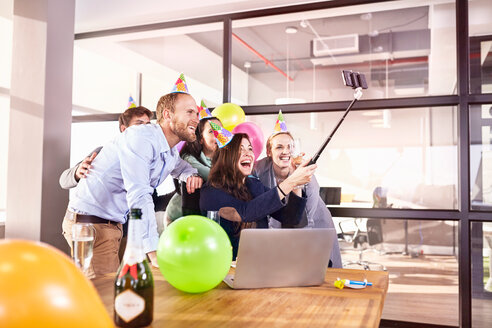 Verspielte Geschäftsleute, die Geburtstag feiern und ein Selfie mit einem Selfie-Stick im Konferenzraum machen - CAIF09298