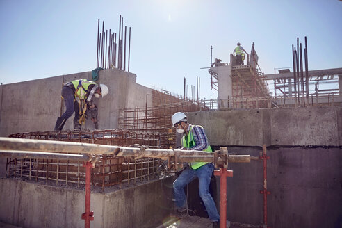 Bauarbeiter bei der Arbeit auf einer sonnigen Baustelle - CAIF09310