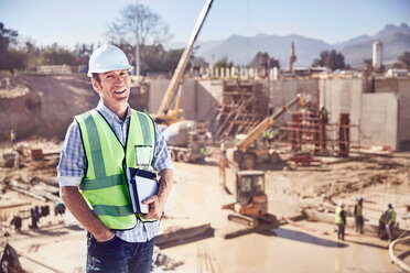 Porträt selbstbewusster Bauarbeiter Vorarbeiter auf sonniger Baustelle - CAIF09319