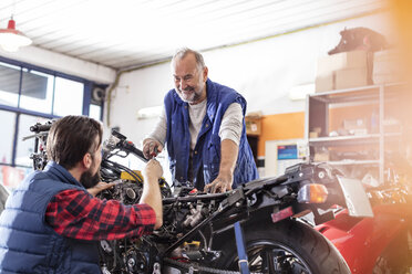 Motorradmechaniker reparieren Motorrad in der Werkstatt - CAIF09345