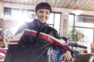 Portrait confident female motorcycle mechanic in workshop - CAIF09348
