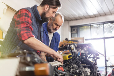 Motorradmechaniker reparieren Motorrad in der Werkstatt - CAIF09350