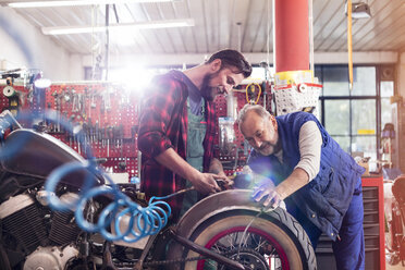 Motorradmechaniker reparieren Motorrad in der Werkstatt - CAIF09359