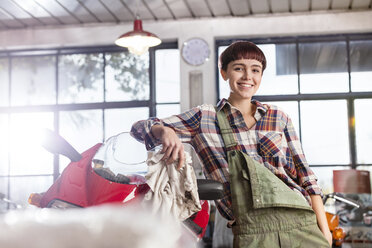 Portrait confident female motorcycle mechanic in workshop - CAIF09363