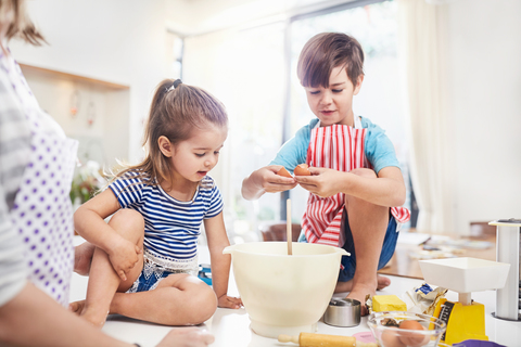 Junge und Mädchen, Bruder und Schwester, backen auf dem Küchentisch, lizenzfreies Stockfoto