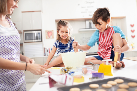 Mutter und Kinder backen Kekse in der Küche, lizenzfreies Stockfoto