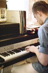 Seitenansicht eines Mannes, der zu Hause Klavier spielt - CAVF04501