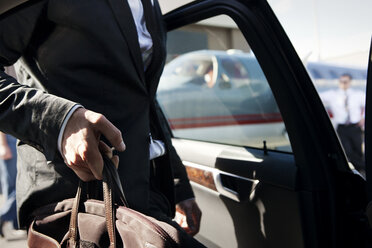 Midsection of businessman getting in car - CAVF04570