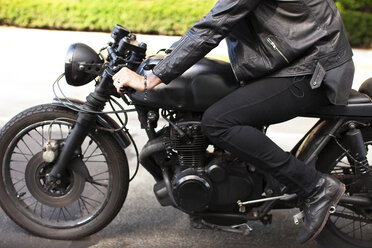 Cropped image of man sitting on motorcycle at road - CAVF04687