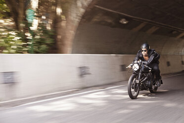 Man wearing sunglasses riding motorcycle on road - CAVF04689