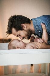 Father rubbing nose with son at home - CAVF04704