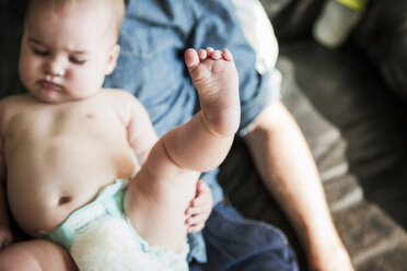 Hoher Blickwinkel auf einen kleinen Jungen, der mit seinem Vater zu Hause sitzt - CAVF04713