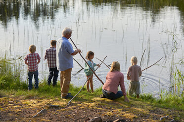 Grandparents and grandchildren fishing at lakeside - CAIF09423