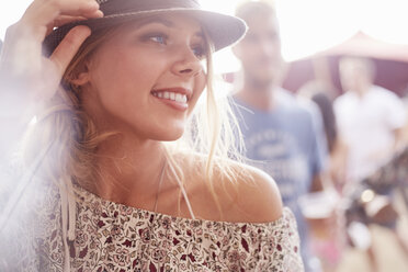 Close up smiling young blonde woman at music festival - CAIF09445