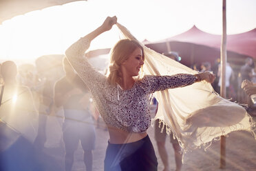 Junge Frau tanzt mit Kopftuch auf einem Musikfestival - CAIF09453