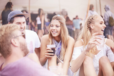 Young friends hanging out drinking at music festival - CAIF09456