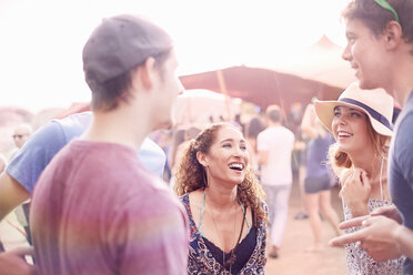 Junge Freunde, die sich auf einem Musikfestival unterhalten - CAIF09461