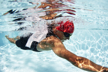 Männlicher Schwimmer, der im Schwimmbad unter Wasser schwimmt - CAIF09473