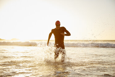 Männlicher Triathlet beim Auslaufen aus dem Meer - CAIF09475