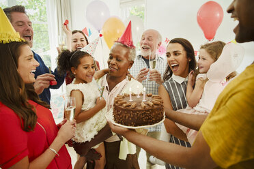 Multi-generation family celebrating birthday with chocolate cake - CAIF09532