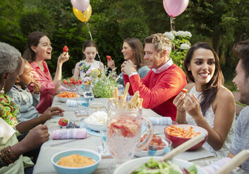 Familie und Freunde genießen Geburtstagsgartenparty am Terrassentisch - CAIF09534