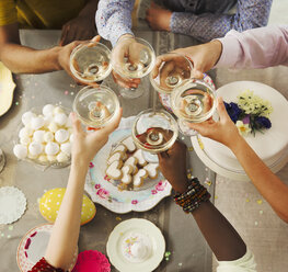 Draufsicht auf Freunde, die mit Sektgläsern auf das Osterdessert anstoßen - CAIF09545