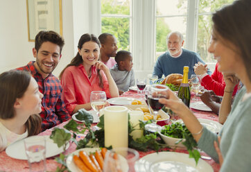 Multiethnische Mehrgenerationenfamilie beim Weihnachtsessen am Tisch - CAIF09552