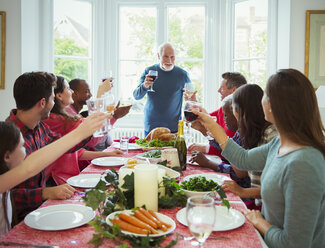 Großvater stößt beim Weihnachtsessen mit Wein an - CAIF09555