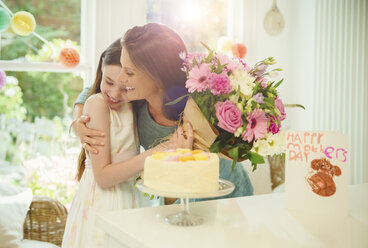 Liebevolle Tochter schenkt ihrer Mutter zum Muttertag einen Blumenstrauß - CAIF09559