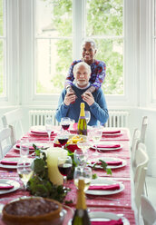 Porträt lächelndes multiethnisches Seniorenpaar am Weihnachtstisch - CAIF09561