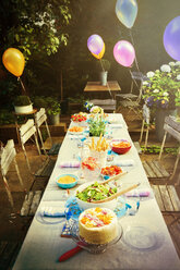 Luftballons und Essen auf dem Terrassentisch einer Gartenparty - CAIF09569