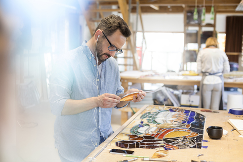 Glasmaler bei der Arbeit im Atelier, lizenzfreies Stockfoto