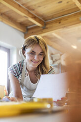 Smiling artist working in studio - CAIF09597