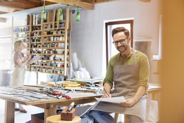 Porträt lächelnder Glasmaler bei der Arbeit im Atelier - CAIF09598