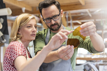 Künstler der Glasmalerei untersuchen Glasstücke im Atelier - CAIF09631