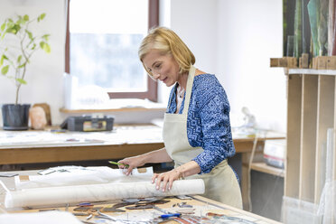 Glasmaler bei der Überprüfung von Zeichnungen im Atelier - CAIF09648