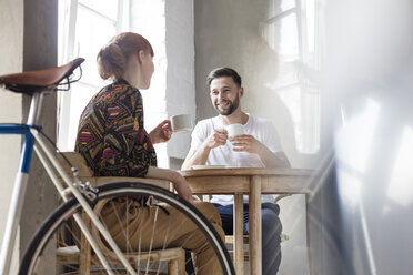 Couple talking and drinking coffee at table - CAIF09691